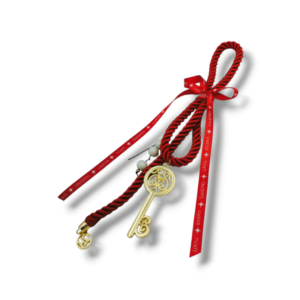 Χειροποίητο διακοσμητικό γούρι κλειδί με λαμπερό κορδόνι ρεγιόν σε κόκκινο χρώμα.